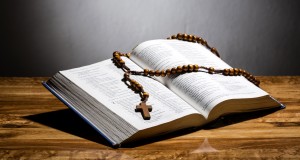 Holy Bible and Rosary with glow in the background